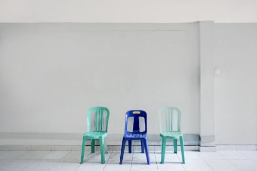 two blue and green chairs in a room at Hotel O Medan near Universitas Sumatera Utara formerly Surya Residence 2 in Medan