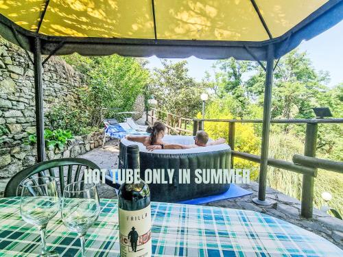 a man and woman in a hot tub on a deck at Holiday Home Vittorio by Interhome in Montorgiali