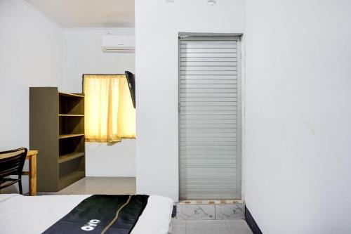 a bedroom with a bed and a closet at Hotel O Medan near Universitas Sumatera Utara formerly Surya Residence 2 in Medan