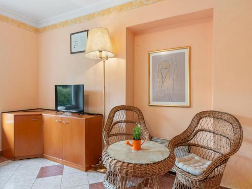 a living room with a table and two chairs and a tv at Holiday Home Sezímky by Interhome in Stvolínky