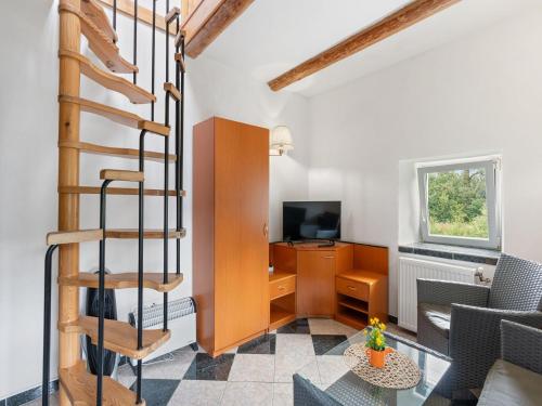 a spiral staircase in a living room with a desk at Holiday Home Sezímky by Interhome in Stvolínky