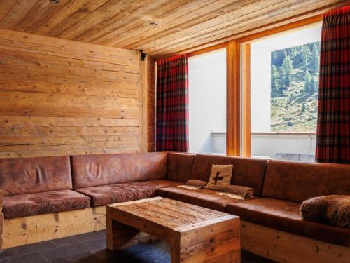 a brown leather couch in a room with windows at Apartment Rosablanche D Attique by Interhome in Siviez