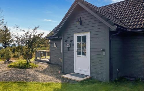 a black house with a white door and a yard at Stunning Home In Korssund With Wifi in Våge