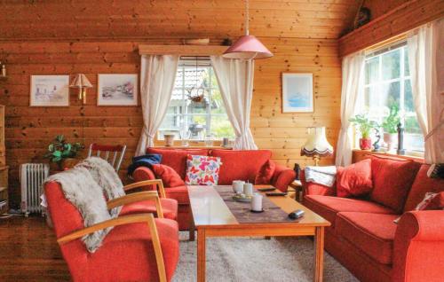 a living room with red couches and a table at Stunning Home In Korssund With Wifi in Våge