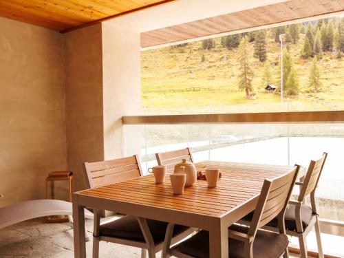 a dining room table with chairs and a large window at Apartment Rosablanche E 108 by Interhome in Siviez