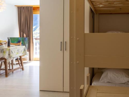 ein Schlafzimmer mit einem Etagenbett und ein Esszimmer mit einem Tisch in der Unterkunft Apartment Mont Fort 35 by Interhome in Siviez