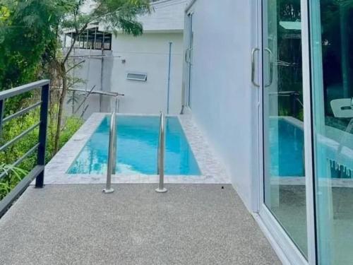 ein Swimmingpool außerhalb eines Hauses in der Unterkunft The Green Valley Escape in Ban Ko Khwan