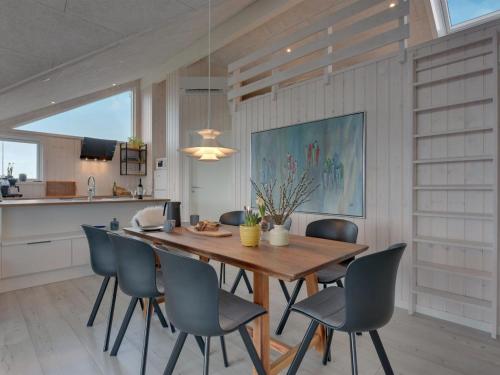 a dining room with a wooden table and chairs at Holiday Home Gubbe - 500m from the sea by Interhome in Lakolk
