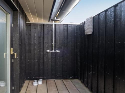 a bathroom with a black wall and a shower at Holiday Home Gubbe - 500m from the sea by Interhome in Lakolk