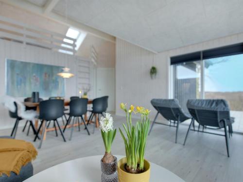 a living room with chairs and a table with flowers at Holiday Home Gubbe - 500m from the sea by Interhome in Lakolk