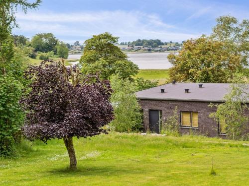 a house with a tree in front of a building at Holiday Home Harka - 100m to the inlet by Interhome in Roskilde