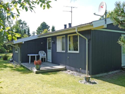 a small house with a porch and a table at Holiday Home Menard - 400m from the sea by Interhome in Ørsted