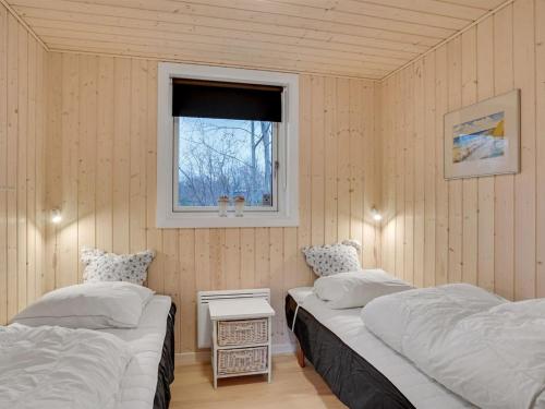 two beds in a room with a window at Holiday Home Thora - 800m from the sea by Interhome in Nyrup