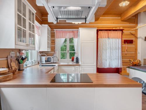 a kitchen with white cabinets and a wooden ceiling at Holiday Home Roubenka Maleč by Interhome in Strašín
