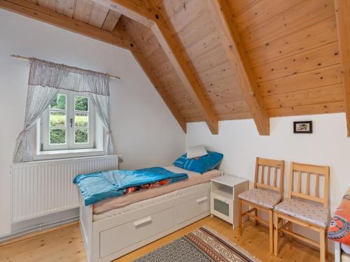 a bedroom with a bed and a window and a chair at Holiday Home Roubenka Maleč by Interhome in Strašín