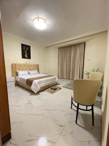a bedroom with a king sized bed and a chair at Kidy guest house in Addis Ababa