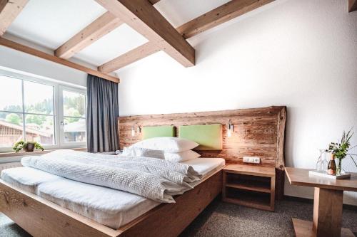a bedroom with a large bed with a wooden headboard at Haus Kapeller in Sankt Jakob in Haus