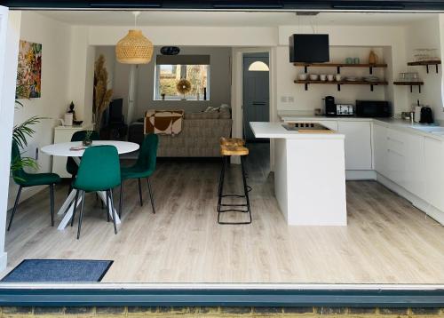 a kitchen and living room with a table and chairs at 2 bedroom cottage in Bromley suitable for 4 people in Bickley