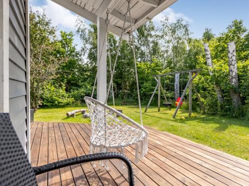 a porch with a swing and a playground at Holiday Home Anabela - from the sea by Interhome in Hadsund