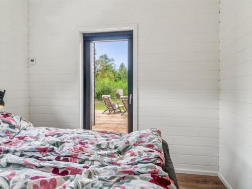 a bedroom with a bed and a door leading to a patio at Holiday Home Rakita - 75m from the sea by Interhome in Tjørneholm