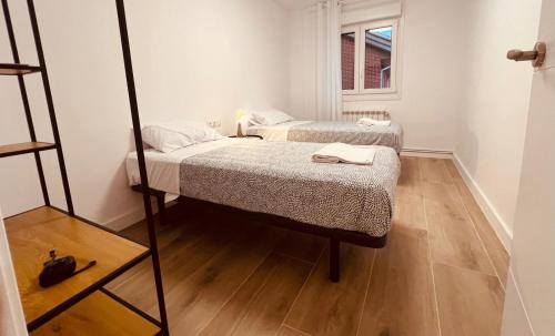 2 łóżka w małym pokoju z lustrem w obiekcie Apartamento El mirador de San Vicente w mieście San Vicente de la Sonsierra
