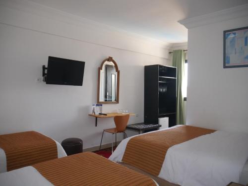 ワルザザートにあるRose Valley Hotelのベッド2台とテーブルがあるホテルの部屋