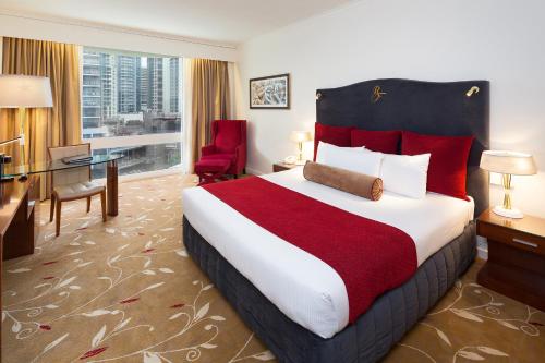 a hotel room with a large bed and a desk at Royal On The Park in Brisbane