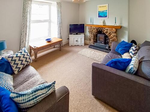 a living room with two couches and a fireplace at Rockhopper Cottage in Brixham