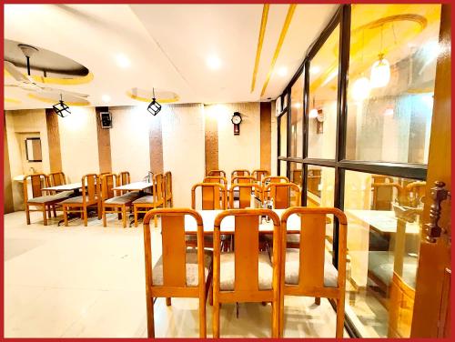 a dining room with tables and chairs in a restaurant at HOTEL THE MOON - Near Mall Road & Naini Lake View - LIFT -Free Parking -Restaurant -Wi-Fi Available- Ambience with Valley- A Top Rated Hotel IN Nainital in Nainital
