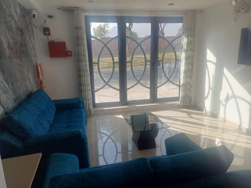 a living room with two blue couches and a glass table at Hospodaje Aeropuerto in Zamacola
