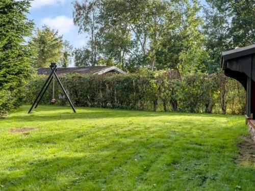 a large yard with a swing in the grass at Holiday Home Neli - 850m to the fjord by Interhome in Storvorde