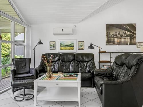a living room with a leather couch and two chairs at Holiday Home Neli - 850m to the fjord by Interhome in Storvorde