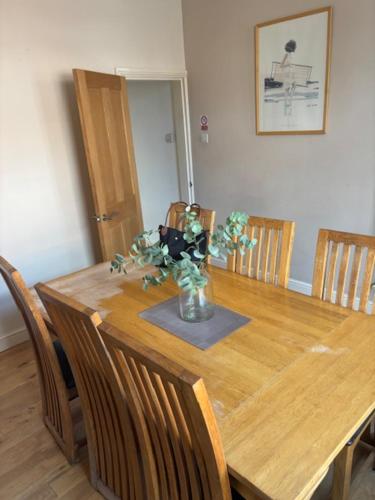 a dining room table with a vase of flowers on it at Holiday Home in Kidderminster in Kidderminster