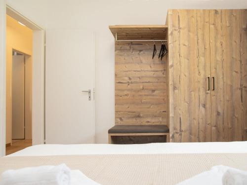 a bedroom with a bed and a wooden wall at Apartment La Siala Apt-28 by Interhome in Falera