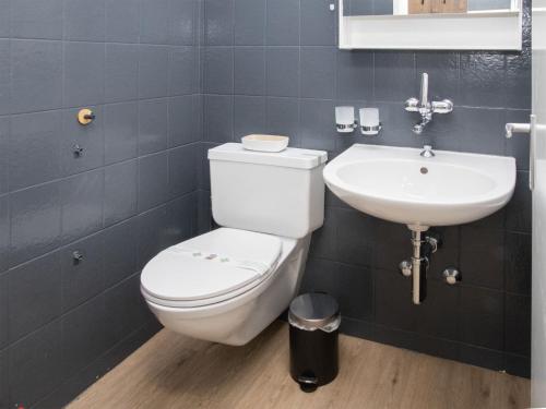 a bathroom with a white toilet and a sink at Apartment La Siala Apt-28 by Interhome in Falera