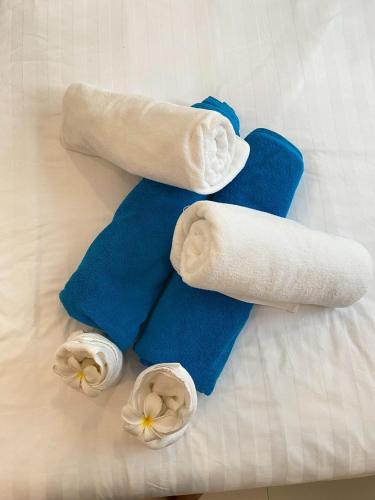 een groep handdoeken en bloemen op een bed bij Serene Hillside Hideaway in Ban Ko Khwan