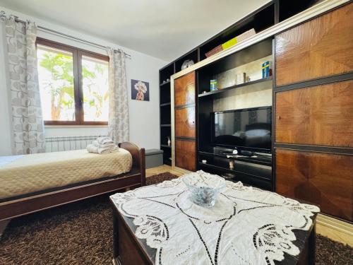 a bedroom with a bed and a tv and a table at La Cinisara in Carini