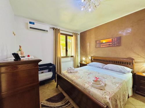 a bedroom with a bed with a dresser and a window at La Cinisara in Carini