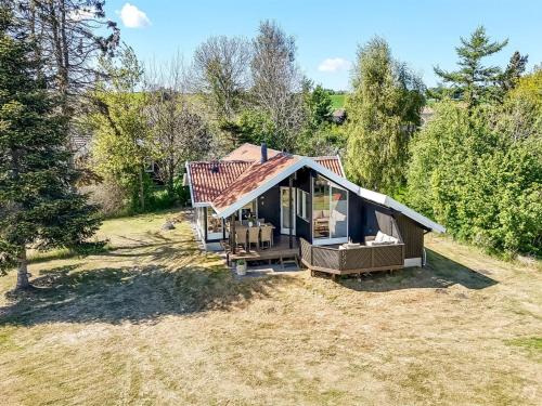 a small house with a roof on a field at Holiday Home Ama - 250m from the sea by Interhome in Knebel