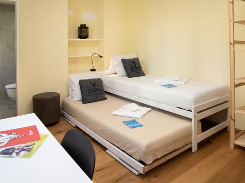 a room with two beds and a table with a lamp at Apartment La Siala Apt-63 by Interhome in Falera