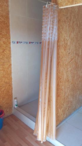 a shower with an orange shower curtain in a bathroom at AMUTUY Dormis in Ciudad Lujan de Cuyo