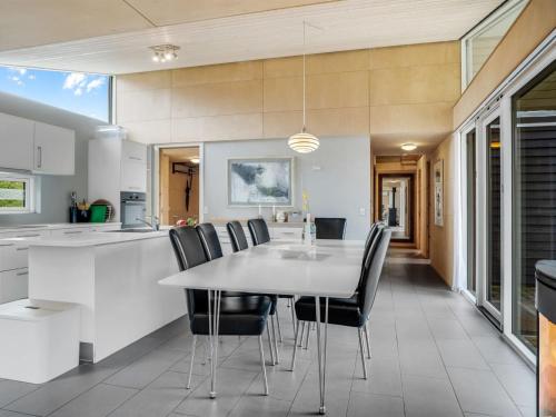 a kitchen and dining room with a table and chairs at Holiday Home Ginne - 1km to the fjord by Interhome in Løgstør