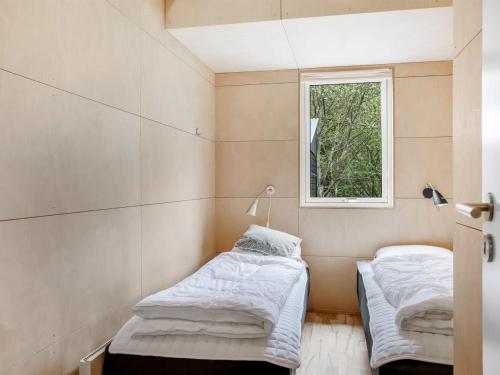 two beds in a room with a window at Holiday Home Ginne - 1km to the fjord by Interhome in Løgstør
