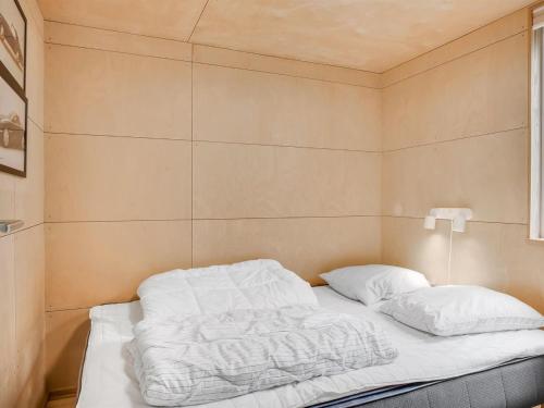 a bed with white sheets and pillows in a room at Holiday Home Ginne - 1km to the fjord by Interhome in Løgstør