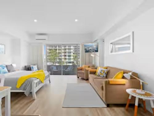 a bedroom with a bed and a couch at Classic Coastal Beachfront, Surfers Paradise-Pool in Gold Coast