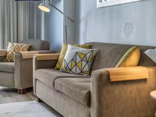 a living room with a couch and a chair at Classic Coastal Beachfront, Surfers Paradise-Pool in Gold Coast