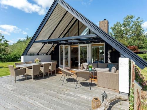 a patio with chairs and a couch and a table at Holiday Home Frodde - 200m from the sea by Interhome in Østerby