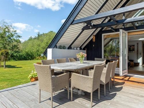 a patio with a table and chairs on a deck at Holiday Home Frodde - 200m from the sea by Interhome in Østerby