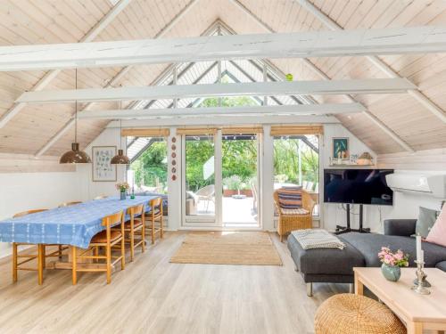a dining room and living room with a table and chairs at Holiday Home Frodde - 200m from the sea by Interhome in Østerby