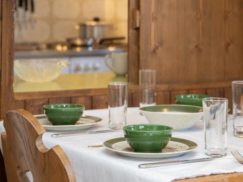 a table with green bowls and plates on it at Apartment La Siala Apt-51 by Interhome in Falera
